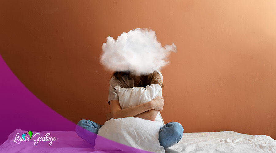 Primer plano de una adolescente sentada en un pupitre con la mirada baja y una expresión de angustia. La imagen captura la sensación de malestar e incomodidad que provoca la ansiedad social en un entorno académico.